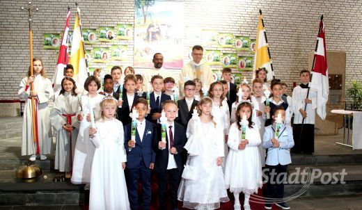 Fast 25 Kinder aus Bergen-Enkheim feierten mit Pfarrer Uwe Hahner und Pater Joseph ihre Erstkommunion. Foto: zko
